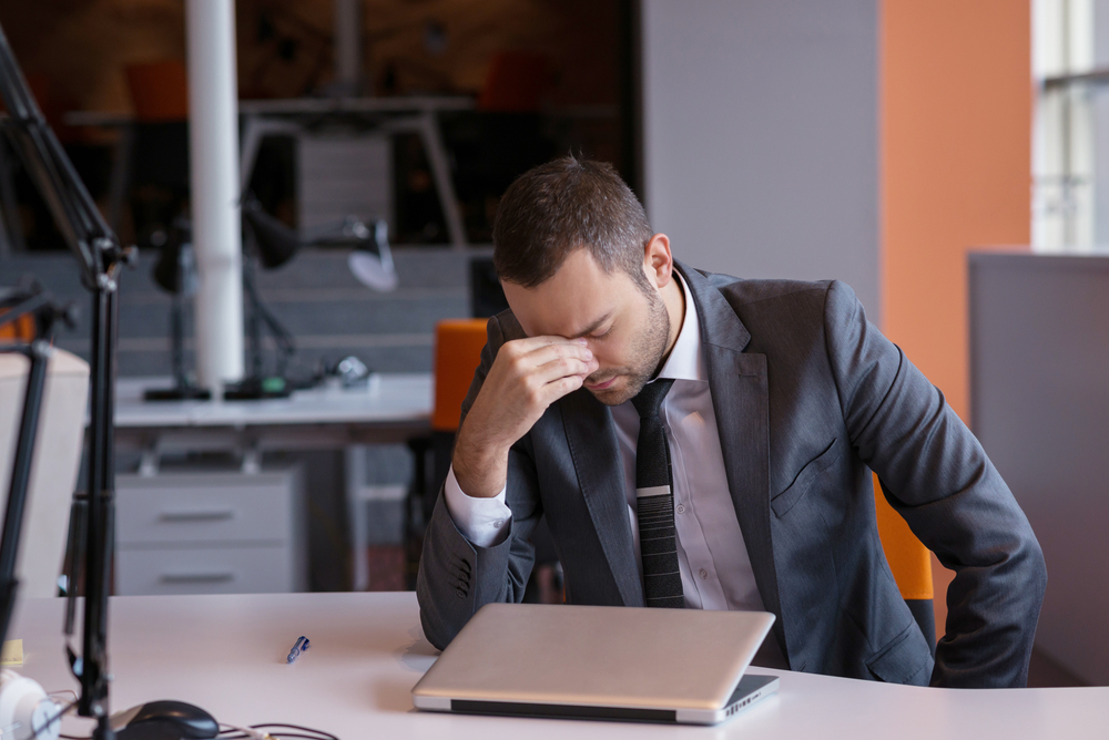 Frustrated Young Business Man Working On Laptop Computer At Office